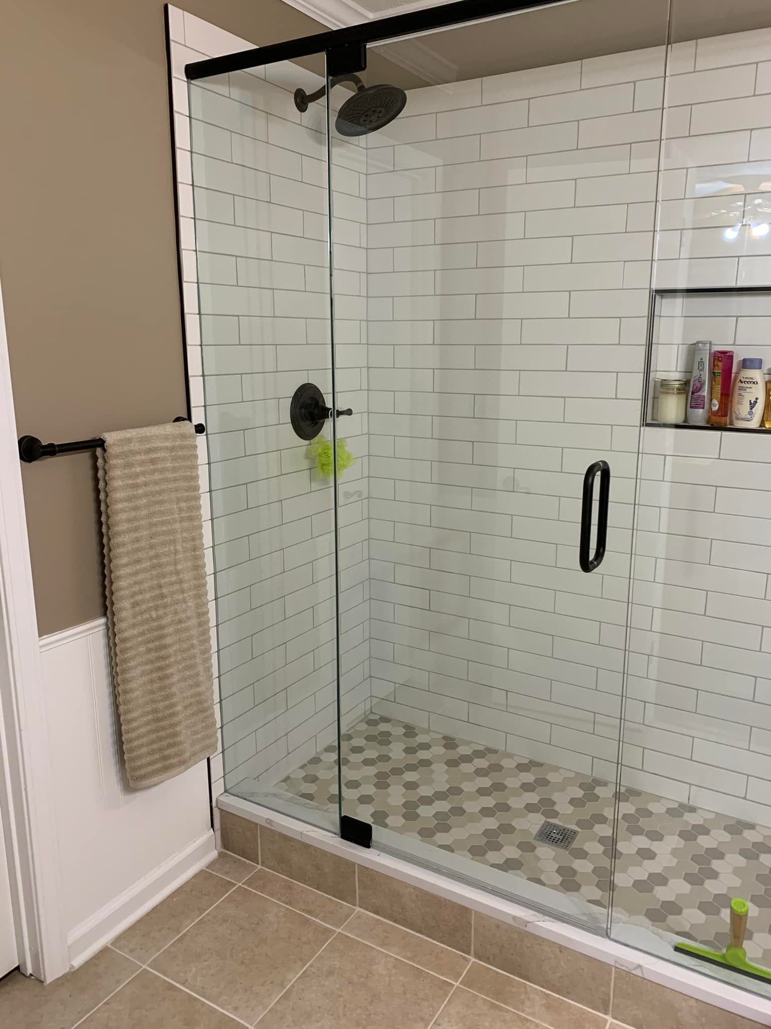 White tiled shower with dark fixtures